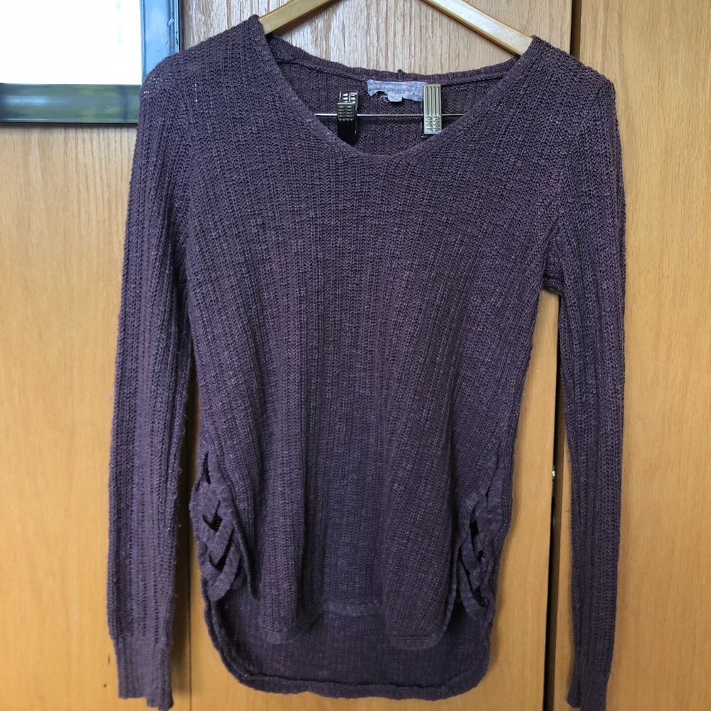 Plum colored sweater with cut/cross bottom sides.